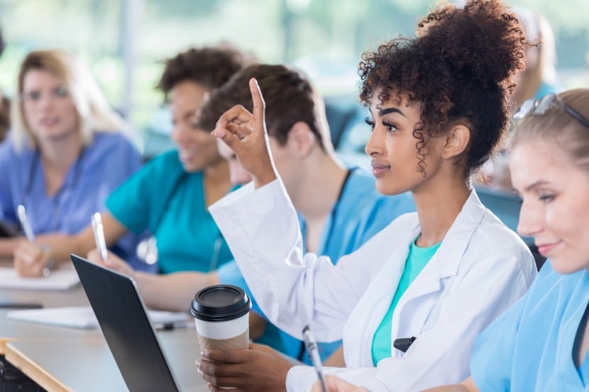 african american female raising hand with a question in classroom with pre-med students