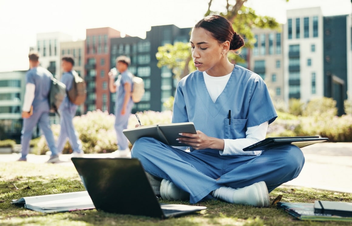 Woman, nurse or student writing with book for internship, studying or research at med school. Female person, healthcare candidate or intern taking notes with laptop for medical exam or test at campus