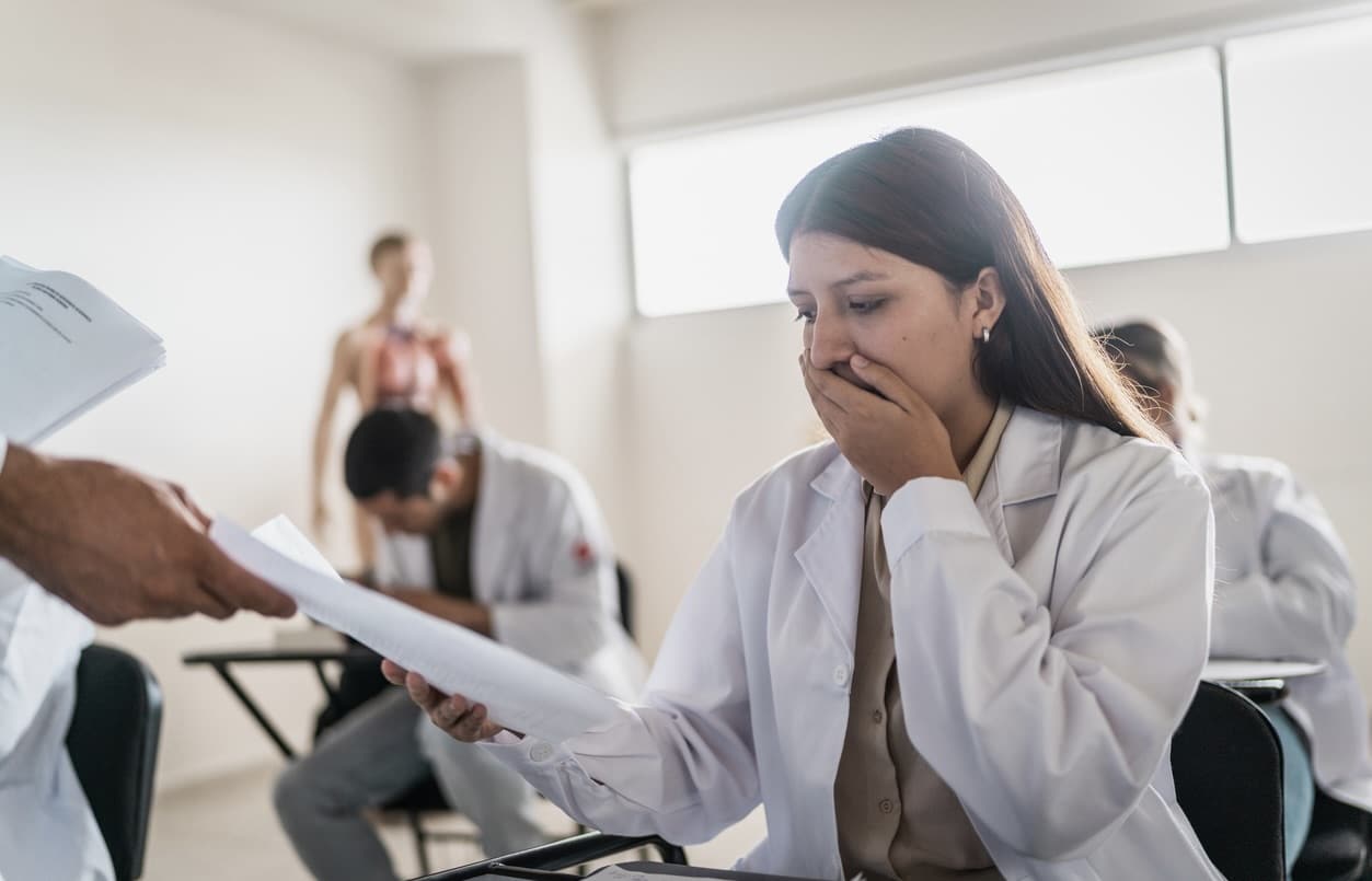 Worried young medical student looking to educational exam during class at university